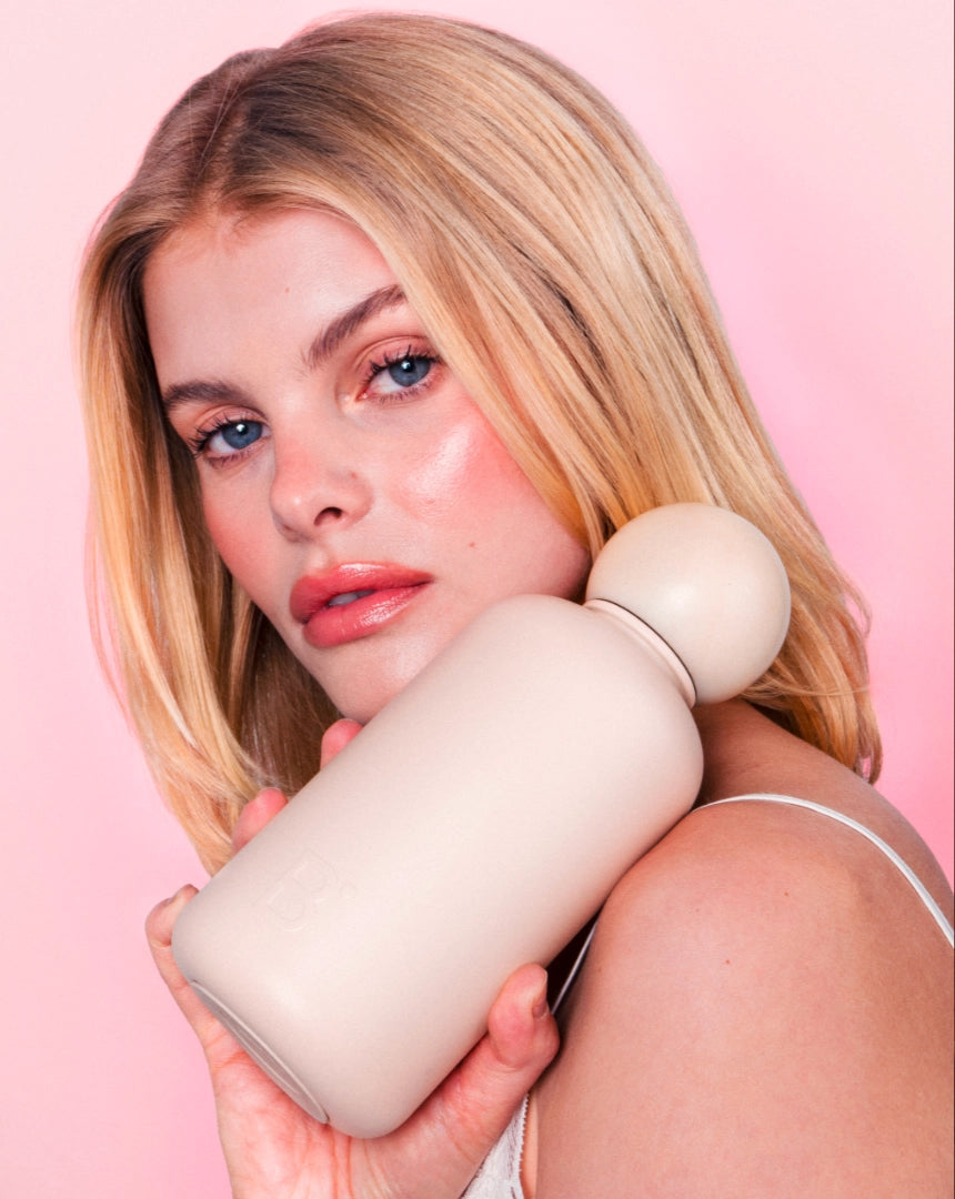 Woman holding Celine luxury water bottle in beige stainless steel